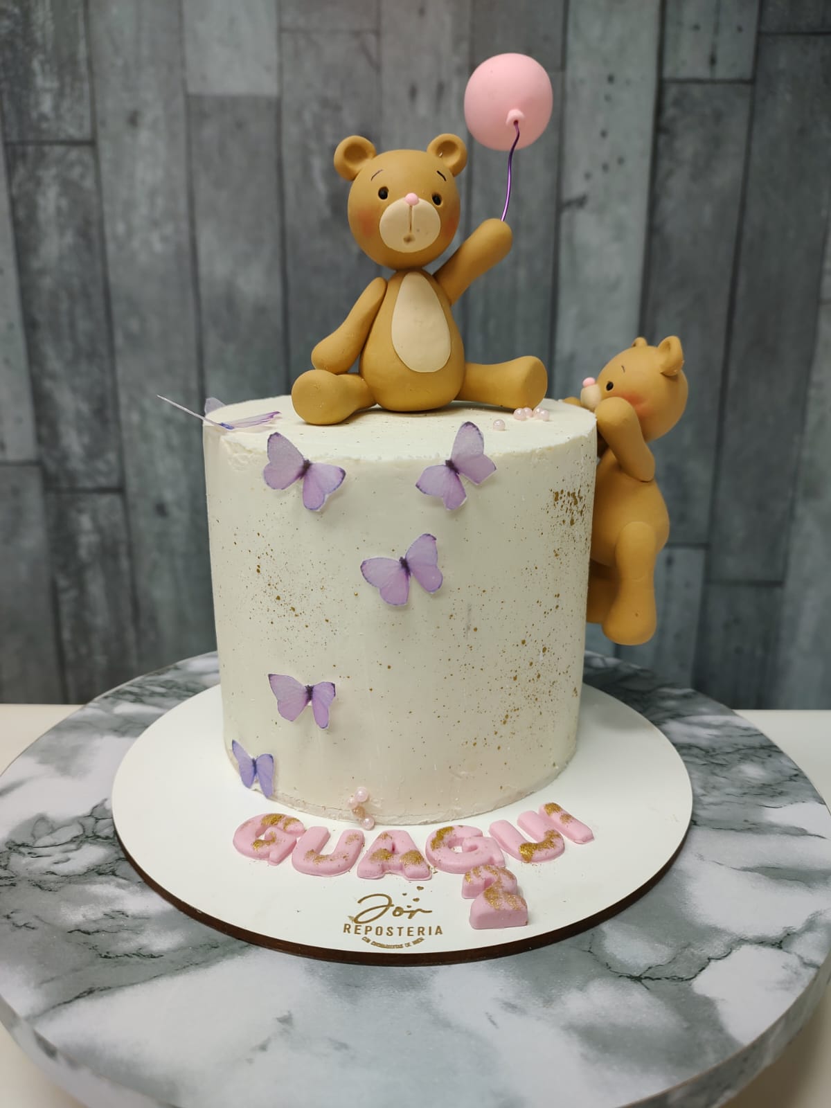 Torta decorada con ositos, mariposas y detalles en rosa, hecha por Jor.